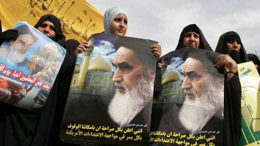Women hold posters of Shi'ite Iranian cleric Ayatollah Khomeini to commemorate the Al-Quds (Jerusalem) Day and to show support for the Palestinians, during a rally in Basra, 550 km (340 miles) south of Baghdad, October 20, 2006.    REUTERS/Atef Hassan   (IRAQ) - RTR1IIUAi