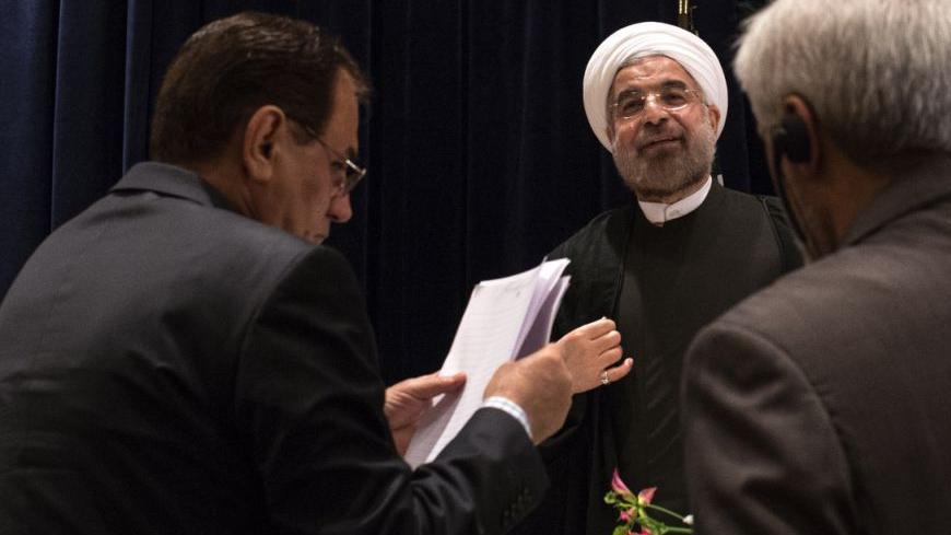 Iran's President Hassan Rouhani (C) is approached by staff members after a news conference in New York September 27, 2013.  New Iranian President Rouhani said on Friday he wanted talks with major powers on Iran's nuclear program to yield results in a short period of time and that the improved mood in U.S.-Iranian relations could lead to better ties.  REUTERS/Adrees Latif (UNITED STATES - Tags: POLITICS ENERGY) - RTX142AH