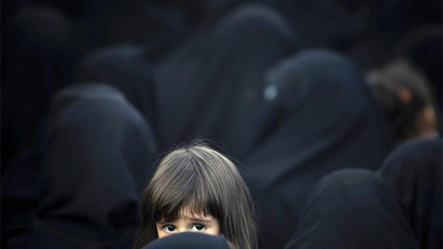 EDITORS' NOTE: Reuters and other foreign media are subject to Iranian restrictions on leaving the office to report, film or take pictures in Tehran.An Iranian girl looks on as she and her mother attend a religious ceremony to commemorate the death anniversary of Fatima, daughter or Prophet Mohammad, in southern Tehran May 17, 2010. REUTERS/Morteza Nikoubazl (IRAN - Tags: ANNIVERSARY RELIGION) - RTR2E0C8