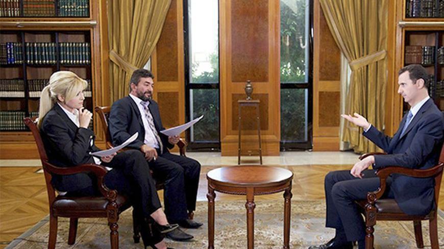Syria's President Bashar al-Assad (R) speaks during an interview with Turkey's Halk TV in Damascus, in this handout photograph distributed by Syria's national news agency SANA on October 4, 2013. Assad has told Turkey it will pay a heavy price for backing rebels fighting to oust him, accusing it of harbouring "terrorists" along its border who would soon turn against their hosts. In an interview with Turkey's Halk TV due to be broadcast later on Friday, Assad called Turkish Prime Minister Tayyip Erdogan "big