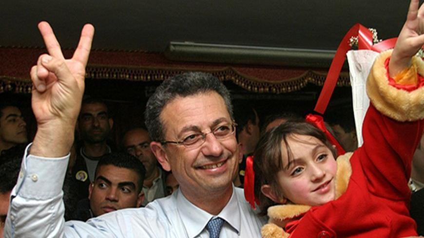Former Palestinian presidential election candidate Mustafa Barghouti holds a young girl during a rally in Hebron.  Former Palestinian presidential election candidate Mustafa Barghouti (L), who is secretary general of al-Mubadara Palestinian National committee, holds a young girl during a rally in the West Bank City of Hebron January 14, 2005. REUTERS/Nayef Hashlamoun - RTRKJ5J