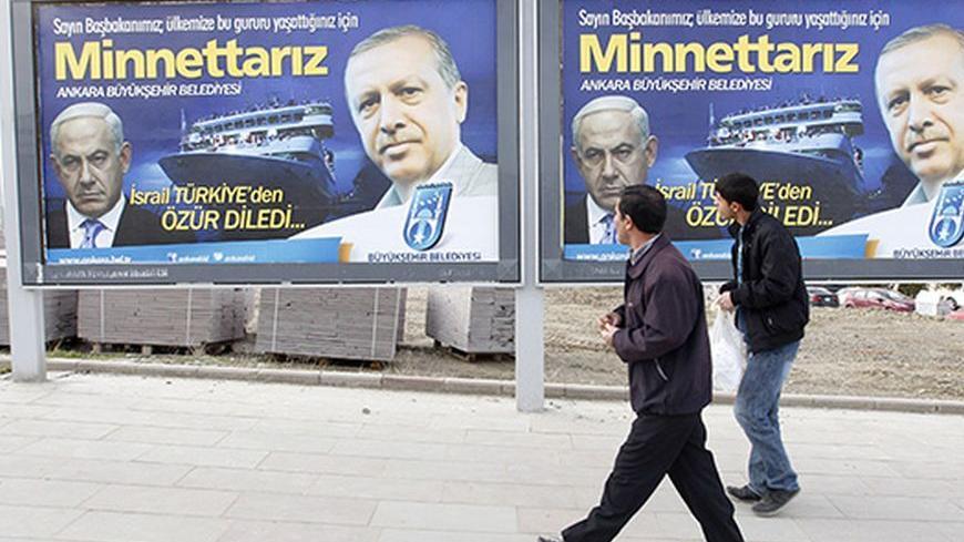 Pedestrians look at billboards with the pictures of Turkey's Prime Minister Tayyip Erdogan (R) and his Israeli counterpart Benjamin Netanyahu (L), in Ankara March 25, 2013. Turkey's Prime Minister Tayyip Erdogan said on Saturday an Israeli apology for the 2010 deaths of nine Turkish pro-Palestinian activists that was brokered by U.S. President Barack Obama met Turkey's conditions and signalled its growing regional clout. The billboard reads, "Israel apologized to Turkey. Dear Prime Minister (Erdogan), We ar