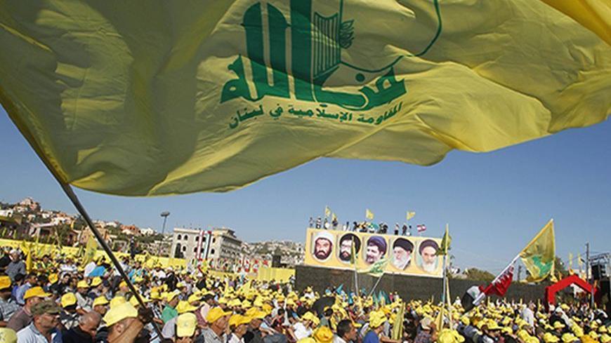 Supporters of Lebanon's Hezbollah leader Sayyed Hassan Nasrallah wave Hezbollah flags as they listen to him via a screen during a rally on the 7th anniversary of the end of Hezbollah's 2006 war with Israel, in Aita al-Shaab village in southern Lebanon, August 16, 2013. Nasrallah renewed his commitment on Friday to the battle in Syria, where the Shi'ite militant group has been fighting alongside President Bashar al-Assad's forces, saying he was ready to go himself if needed. REUTERS/Ali Hashisho    (LEBANON 