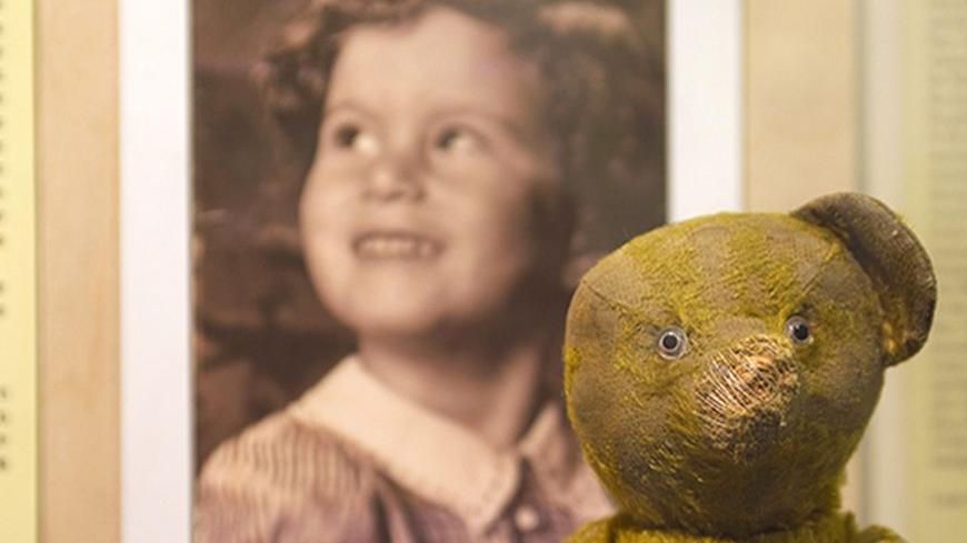 A battered teddy bear belonging to Ina Rennert, a 75-year-old Holocaust survivor, is displayed with a picture of her as a child at the Yad Vashem Holocaust History Museum in Jerusalem April 17, 2011. Rennert had handed over to Yad Vashem for safekeeping the toy she says she once clung to as a little girl while hiding from the Nazis in Poland during World War Two. Thousands of aging Israeli survivors have answered a call by Yad Vashem to hand in Holocaust-era keepsakes to preserve their memory for future gen