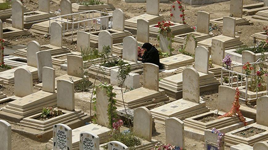 A woman grieves at a cemetery in Baghdad's Adhamiya April 2, 2009.  REUTERS/Ahmed Malik (IRAQ SOCIETY) - RTXDJ6S