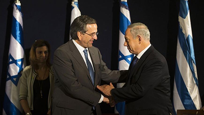 Israel's Prime Minister Benjamin Netanyahu (R) and Greece's Prime Minister Antonis Samaras shake hands during a Government-To-Government (G2G) meeting in Jerusalem October 8, 2013. REUTERS/Ronen Zvulun (JERUSALEM - Tags: POLITICS) - RTX143OX