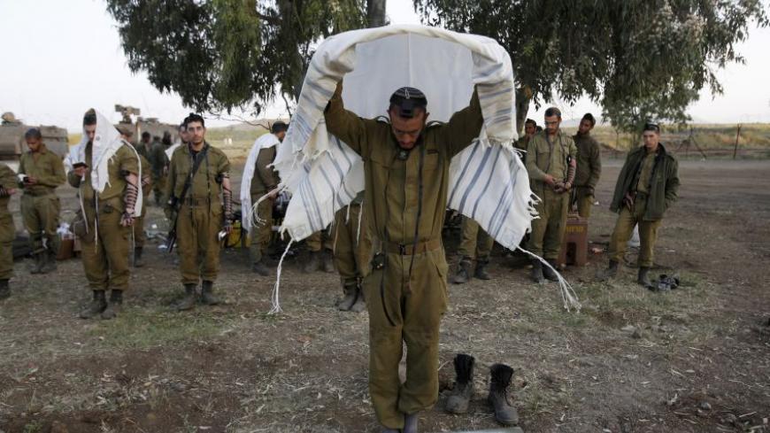 Israeli soldiers from the Golani Brigade pray close to the ceasefire line between Israel and Syria on the Israeli occupied Golan Heights May 7, 2013. Israel played down weekend air strikes close to Damascus reported to have killed dozens of Syrian soldiers, saying they were not aimed at influencing its neighbour's civil war but only at stopping Iranian missiles reaching Lebanese Hezbollah militants. 
REUTERS/Baz Ratner (MILITARY RELIGION) - RTXZDAS