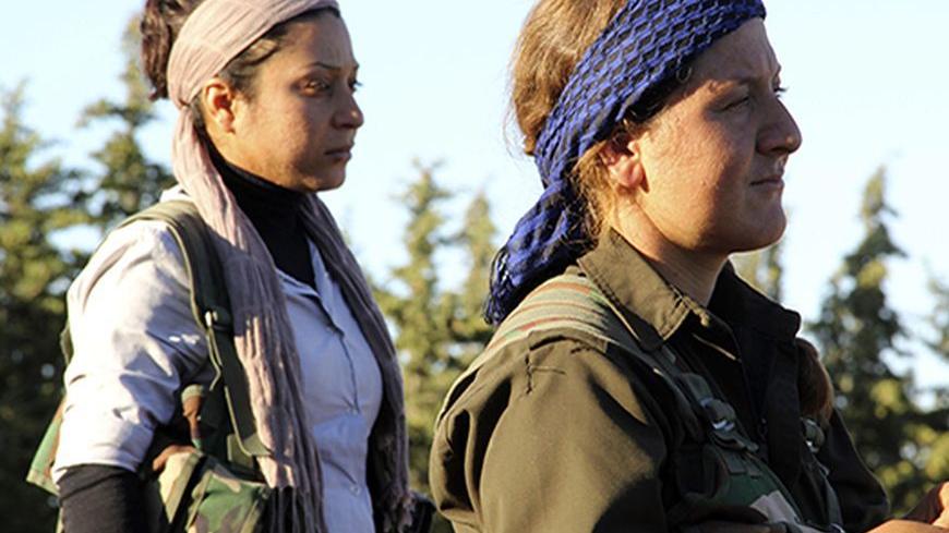 Kurdish female fighters from the Popular Protection Units (YPG) watch their fellow fighters in the Kurdish town of Ifrin, in Aleppo's countryside October 14, 2013. Kurds comprise around 10 percent of Syria's 23 million population. They are concentrated in Ifrin and other areas of the northwest, in parts of Damascus and in the northeastern oil producing area of Qamishli, where there has also been intense fighting between Kurds and al-Qaeda linked Islamic State of Iraq and the Levant fighters. Picture taken O