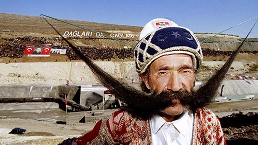 50-year-old Mevlut Dogan of Turkey poses with his 1,5 metres long moustache in front of the irrigation tunnel in the southeast Turkish town of Sanliurfa November 9. He was one of the characters present during the inauguration of the next stage of Turkey's regional development project by opening up the world's largest irrigation tunnel for a ceremonial run - RTXF4TZ