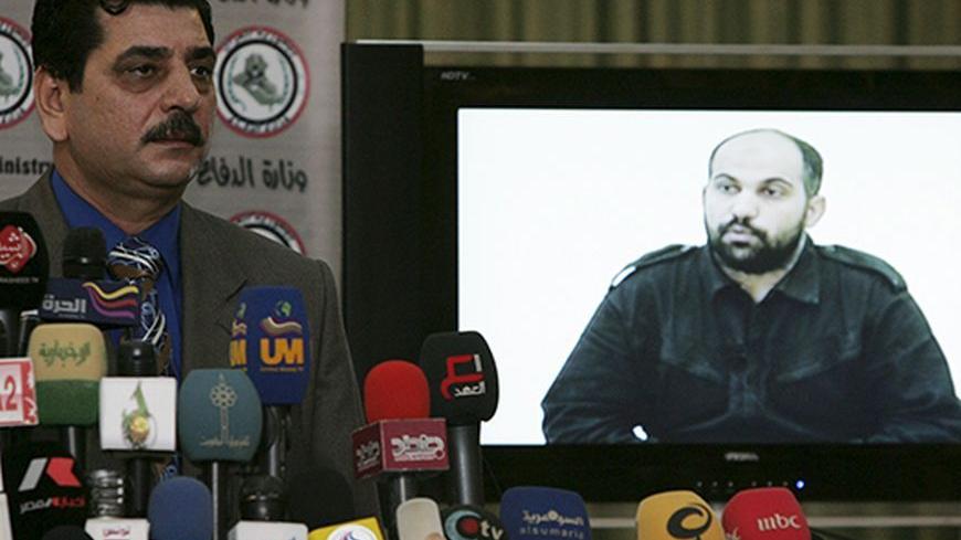 Iraq's Defense Ministry spokesman Major-General Mohammed al-Askari holds a news conference in Baghdad January 18, 2010. Askari showed a picture of an al-Qaeda member named Ali Mamoun Qasim, who they say is a pharmacist responsible for killing military officers and wounding Iraqi police at a hospital in Mosul.  REUTERS/Saad Shalash (IRAQ - Tags: CIVIL UNREST) - RTR290V1