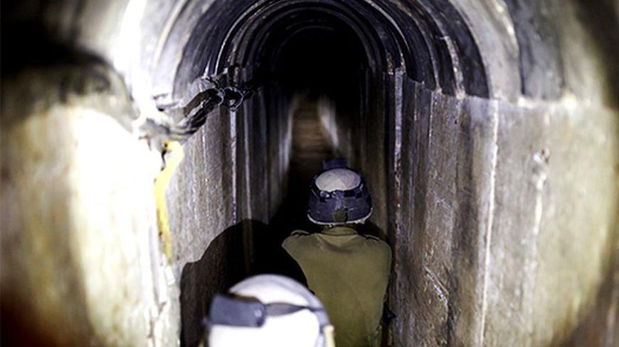 Israeli soldiers stand guard inside a tunnel exposed by the Israeli military near Kibbutz Ein Hashlosha, just outside the southern Gaza Strip October 13, 2013. Israel displayed on Sunday what it called a Palestinian "terror tunnel" running into its territory from the Gaza Strip and said it was subsequently freezing the transfer of building material to the enclave. REUTERS/Amir Cohen (ISRAEL - Tags: POLITICS CIVIL UNREST MILITARY TPX IMAGES OF THE DAY) - RTX149S4
