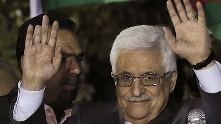 Palestinian President Mahmoud Abbas waves to his supporters upon the arrival of released Palestinian prisoners from Israeli prisons in the West Bank city of Ramallah early October 30, 2013. Israel freed 26 Palestinian prisoners on Wednesday, the second stage of a limited amnesty designed to help U.S.-sponsored peace talks that have been dogged by divisions on both sides. REUTERS/Ammar Awad (WEST BANK - Tags: POLITICS CIVIL UNREST) - RTX14TCR