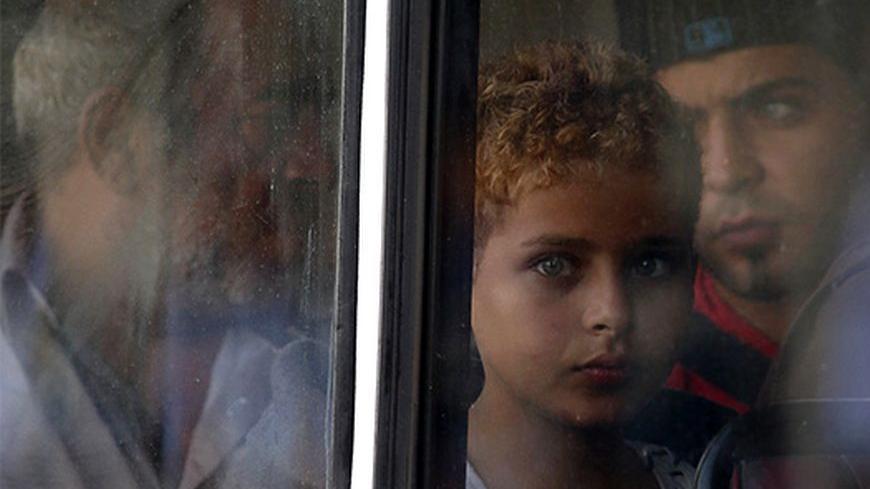 A rescued migrant child looks out of the window of a police bus after arriving at the Armed Forces of Malta Maritime Squadron base at Haywharf in Valletta's Marsamxett Harbour October 12, 2013. Dozens of people died on Friday when a boat carrying around 250 migrants capsized between Sicily and Tunisia, in the second such shipwreck this month, the Italian coastguard said. 147 survivors, believed to all be Syrians, arrived in Malta on Saturday morning, according to local media.
 REUTERS/Darrin Zammit Lupi (MA