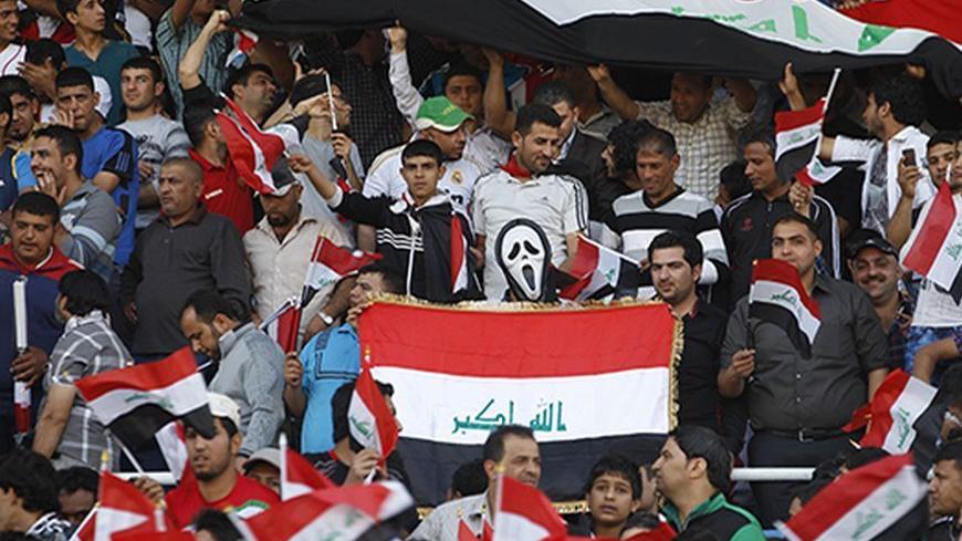 A fan wearing a Ghostface mask from Scream holds an Iraqi flag during Iraq's international friendly soccer match against Syria at Baghdad's Shaab stadium March 26, 2013. Iraq will be allowed to play friendly matches at home again following approval from soccer's world governing body FIFA on Thursday. Iraq were banned from playing all games at home for security reasons after losing a World Cup qualifier 2-0 to Jordan at the Franso Hariri Stadium in Arbil in September 2011. The reprieve does not apply to Worl