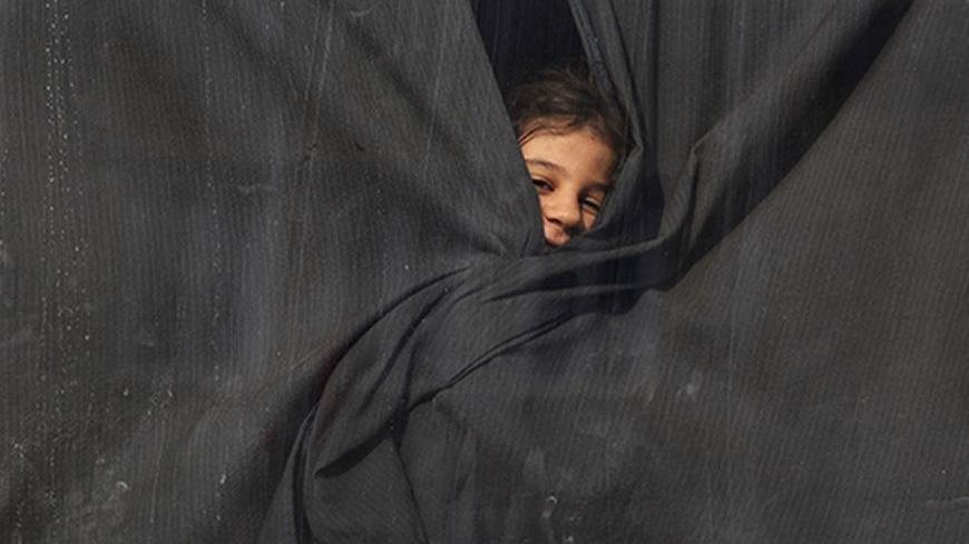A Palestinian girl, who had been living at Yarmouk Palestinian refugee camp in Syria, looks out of a bus window, as the bus arrives at the Lebanese-Syrian border, in al-Masnaa December 18, 2012. More than 1,000 Palestinian refugees living in Syria have crossed into Lebanon in the past 24 hours, a source at the Lebanese border said on Tuesday, after Syrian rebels took control of a Palestinian refugee camp in Damascus. REUTERS/Jamal Saidi  (LEBANON - Tags: POLITICS CIVIL UNREST SOCIETY) - RTR3BPTI