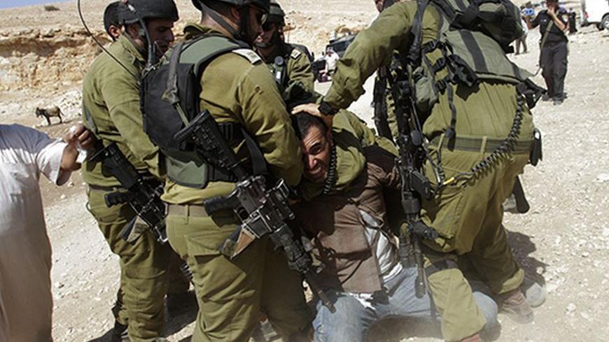 Israeli soldiers detain a Palestinian during scuffles following an attempt by European diplomats to deliver goods to locals in the West Bank herding community of Khirbet al-Makhul, in the Jordan Valley September 20, 2013. Israeli soldiers manhandled European diplomats on Friday and seized a truck full of tents and emergency aid they had been trying to deliver to Palestinians whose homes were demolished earlier this week. REUTERS/Abed Omar Qusini (WEST BANK - Tags: POLITICS CIVIL UNREST MILITARY TPX IMAGES O