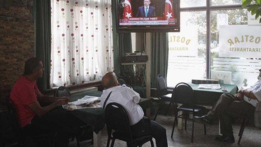 People watch a television broadcasting the speech of Turkish Prime Minister Tayyip Erdogan at a coffee shop in Istanbul September 30, 2013. Turkey may reduce the threshold for a political party to enter parliament to 5 percent of the national vote, or even eliminate the barrier completely, Erdogan said on Monday. The current 10 percent threshold has kept pro-Kurdish groupings outside of parliament and a reform that may help advance a flagging peace process with Kurdish militants. In a major policy speech, E