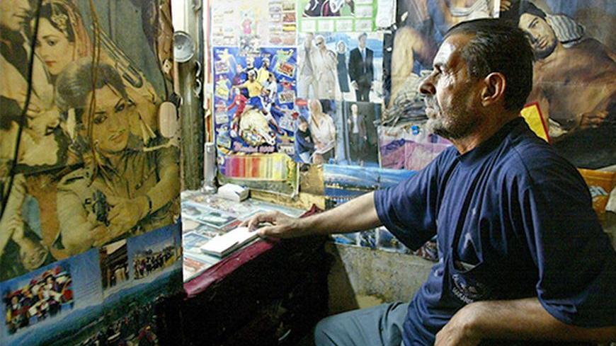 An Iraqi man sells tickets at the Atlas Cinema in the Iraqi city of Basra on May 27, 2003. Basra's cinemas closed this month after threats from radical Muslims but reopened on Tuesday, although they are showing only action and Arabic films and not the more popular "romance" movies. - RTXLZXN