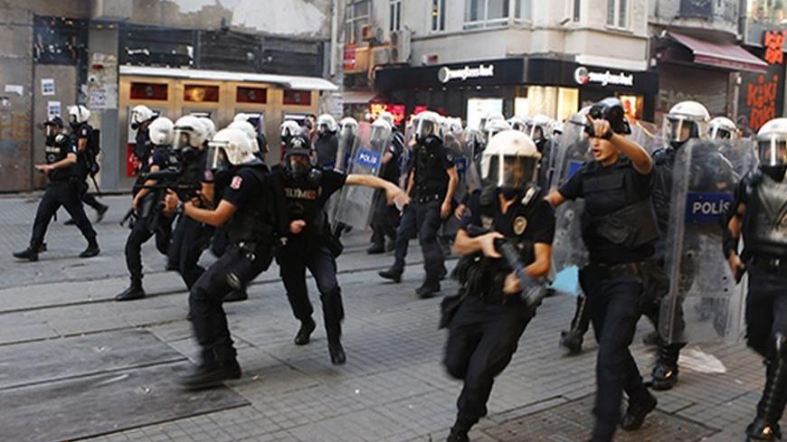 Riot police chase demonstrators during a protest in central Istanbul September 10, 2013. Turkish police fired rounds of teargas to disperse a crowd of several hundred demonstrators rallying in central Istanbul on Tuesday against the death of a protester in the southern province of Hatay earlier in the day, witnesses said. REUTERS/Osman Orsal (TURKEY  - Tags: POLITICS CIVIL UNREST) - RTX13G62