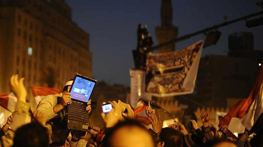 An opposition supporter holds up a laptop showing images of celebrations in Cairo's Tahrir Square, after Egypt's President Hosni Mubarak resigned February 11, 2011. Mubarak stepped down as president of Egypt on Friday after 30 years of rule, handing power to the army and bowing to relentless pressure from a popular uprising after his military support. "New media, mainly satellite channels, have managed to spread the message of the revolution everywhere, including rural areas," said Abdel Fattah of the Al Ah