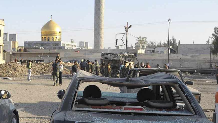 Security and residents inspect the site where a car bomb exploded in front of the gold-domed Shi'ite shrine of Sayyida Zeinab in southern Damascus, June 14, 2012. A car bomb exploded in a car park in southern Damascus, near the gold-domed Shi'ite shrine of Sayyida Zeinab, activists and state media said.The powerful blast caused a deep crater in the tarmac and wrecked several buses, smashing windows of cars across a wide area. Two people were wounded, state news agency SANA reported. REUTERS/Sana/Handout (SY