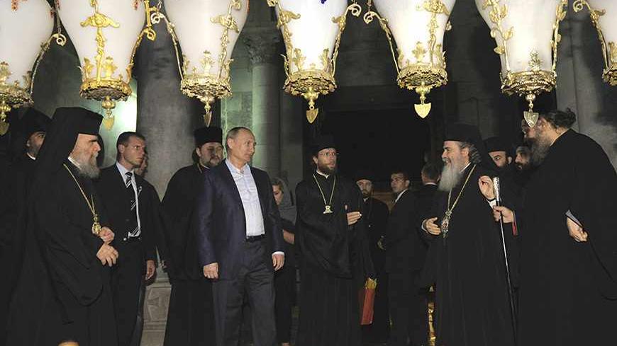 Russia's President Vladimir Putin (5th L) and Greek Orthodox Patriarch of Jerusalem Metropolitan Theophilos (front 2nd R) stand near the Stone of Anointing, where Christians believe the body of Jesus was prepared for burial, at the Church of the Holy Sepulchre in Jerusalem's Old City June 26, 2012. REUTERS/Alexsey Druginyn/RIA Novosti/Pool (JERUSALEM - Tags: POLITICS RELIGION) THIS IMAGE HAS BEEN SUPPLIED BY A THIRD PARTY. IT IS DISTRIBUTED, EXACTLY AS RECEIVED BY REUTERS, AS A SERVICE TO CLIENTS - RTR345VK