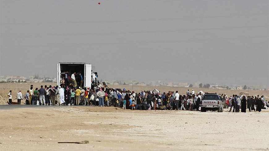 Syrians refugees try to enter a truck which will transport them back to their homeland at the Al-Zaatri refugee camp in the Jordanian city of Mafraq, near the border with Syria July 30, 2013.    REUTERS/Muhammad Hamed (JORDAN - Tags: POLITICS CIVIL UNREST SOCIETY IMMIGRATION) - RTX1258L