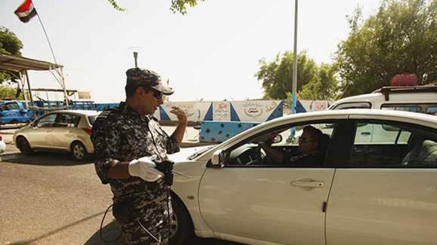 An Iraqi policeman inspects a car using a scanning device at a checkpoint in Baghdad's Abu Nawas street August 29, 2013.   REUTERS/Saad Shalash (IRAQ - Tags: CONFLICT CIVIL UNREST MILITARY TRANSPORT) - RTX13024