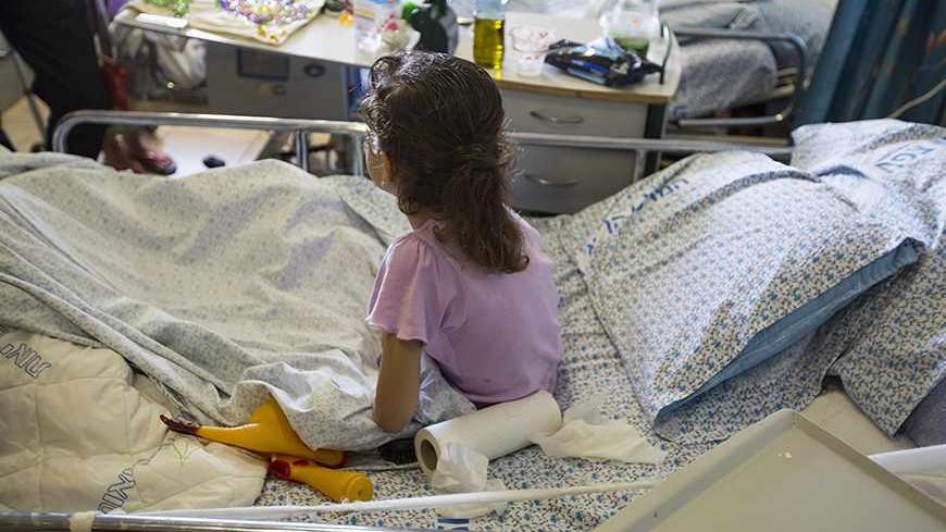 A wounded Syrian girl sits on a hospital bed at Ziv Medical Center in the northern Israeli town of Safed September 9, 2013. What started this year as a trickle is now a steady flow of Syrians, scores of civilians and fighters wounded in the civil war and being discreetly brought across the Golan frontline into Israel - a country with which Syria is formally still at war.  Picture taken September 9, 2013. REUTERS/Baz Ratner (ISRAEL - Tags: POLITICS HEALTH) - RTX13JW4