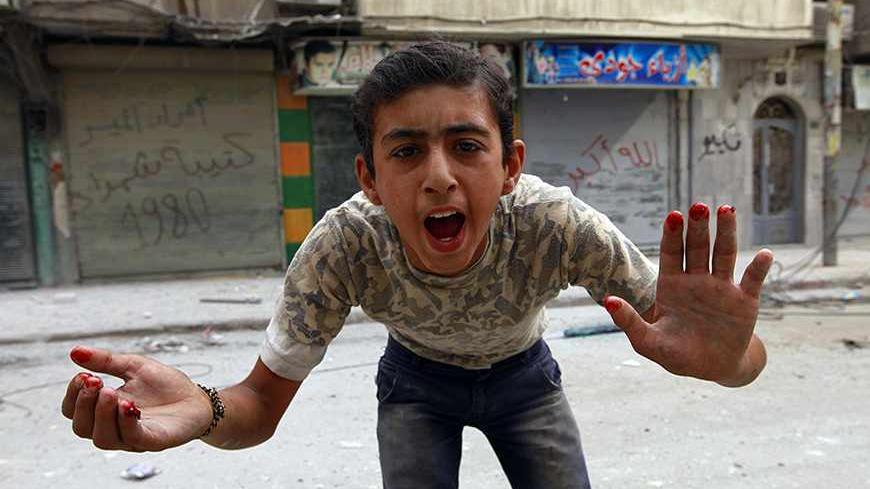 A boy gestures at the camera with blood on his fingers after what activists said was shelling by forces loyal to Syria's President Bashar al-Assad in the al-Myassar neighbourhood of Aleppo September 19, 2013. REUTERS/Hamid Khatib (SYRIA - Tags: CONFLICT CIVIL UNREST TPX IMAGES OF THE DAY) - RTX13R1I