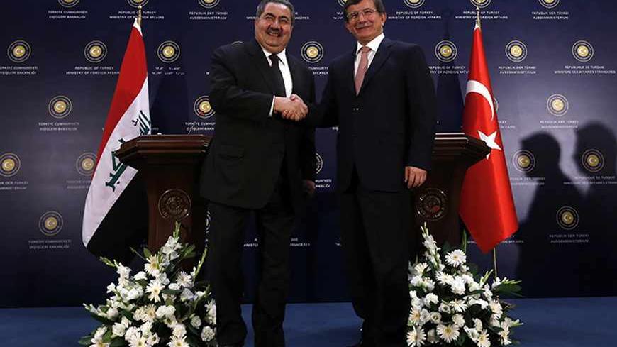 Turkey's Foreign Minister Ahmet Davutoglu (R) shakes hands with his Iraqi counterpart Hoshiyar Zebari after a news conference in Ankara October 25, 2013. REUTERS/Umit Bektas (TURKEY - Tags: POLITICS) - RTX14NP6