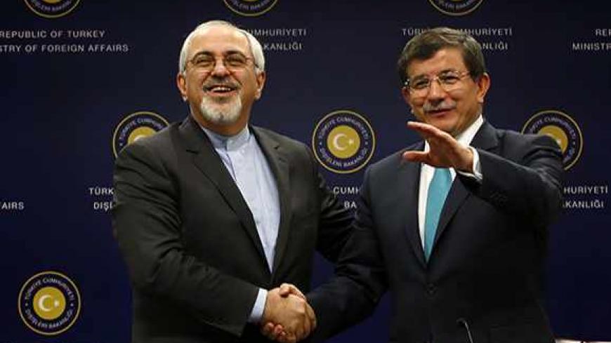 Iranian Foreign Minister Mohammad Javad Zarif (L) shakes hands with his Turkish counterpart Ahmet Davutoglu after a news conference in Ankara November 1, 2013. Turkey and Iran said on Friday they had common concerns about the increasingly sectarian nature of Syria's civil war, signalling a thaw in a key Middle Eastern relationship strained by stark differences over the conflict. REUTERS/Umit Bektas (TURKEY - Tags: POLITICS) - RTX14WOL