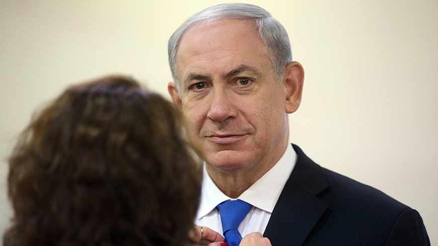 Israel's Prime Minister Benjamin Netanyahu has his tie adjusted before the arrival of Poland's President Bronislaw Komorowski to their meeting in Jerusalem November 4, 2013. REUTERS/Menahem Kahana/Pool (JERUSALEM - Tags: POLITICS) - RTX14ZOS