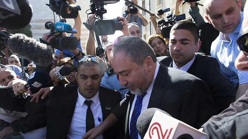 Former Israeli Foreign Minister Avigdor Lieberman (3rd R) is surrounded by members of the media as he leaves the Magistrate Court in Jerusalem, after he was acquitted in a corruption trial November 6, 2013. Israeli Prime Minister Benjamin Netanyahu welcomed Lieberman back to government on Wednesday after the ultra-nationalist politician was acquitted of corruption charges. REUTERS/Ronen Zvulun (JERUSALEM - Tags: POLITICS CRIME LAW TPX IMAGES OF THE DAY) - RTX1523M