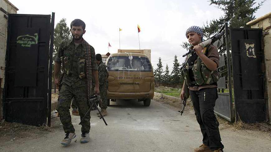 Members of Kurdish People's Protection Units (YPG) walk after capturing a military base that belonged to the Islamist rebels near Ras al-Ain, in the province of Hasakah, November 6, 2013. Redur Xelil, spokesman for the armed wing of the Syrian Kurdish Democratic Union Party (PYD), said Kurdish militias had seized the city of Ras al-Ain and all its surrounding villages. Syrian Kurdish fighters have captured more territory from Islamist rebels in northeastern Syria, a Kurdish militant group said on Monday, ti