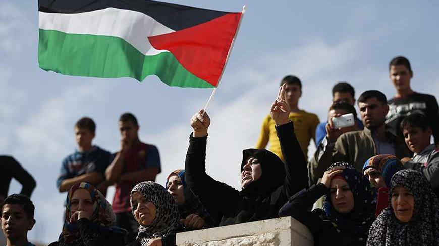 A Palestinian woman waves a flag during the funeral of Anas al-Atrash, 23, in the West Bank city of Hebron November 8, 2013. Israeli troops shot and killed al-Atrash who tried to stab one of them at a West Bank checkpoint on Friday, a police spokesman said, the second Palestinian fatality in the territory in a few hours. REUTERS/Mohamad Torokman (WEST BANK - Tags: POLITICS CIVIL UNREST) - RTX155AG