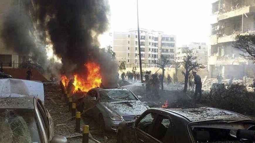 Civil Defence personnel extinguish a fire on cars at the site of the explosions near the Iranian embassy in Beirut November 19, 2013. The cultural attache Ebrahim Ansari at the Iranian embassy in Beirut was among at least 23 people killed in two explosions on Tuesday, Lebanese sources said. Lebanese Health Minister Ali Hassan Khalil said the explosions wounded 146 people.     REUTERS/Ahmad Yassine (LEBANON - Tags: POLITICS CIVIL UNREST) - RTX15JQX