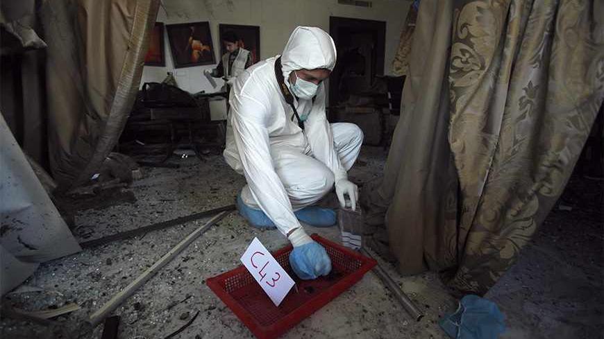 A forensic inspector collects evidence at the site of the two suicide bombings that occurred on Tuesday near Iran's embassy compound in Beirut November 20, 2013. Two suicide bombings rocked Iran's embassy compound in Lebanon on Tuesday, killing at least 23 people including an Iranian cultural attache and hurling bodies and burning wreckage across a debris-strewn street. REUTERS/Sharif Karim (LEBANON - Tags: POLITICS CIVIL UNREST) - RTX15LK0