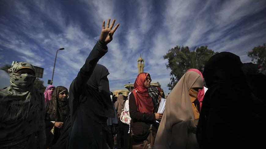 Female students of Al-Azhar University, supporters of the Muslim Brotherhood and ousted Egyptian President Mohamed Mursi, shout slogans against the military and interior ministry while gesturing with four fingers after last night's clashes as they block Moustafa Al Nahas street in front of Al-Azhar University Campus at Cairo's Nasr City district, November 21, 2013. A student was shot dead in clashes late Wednesday between supporters of ousted Egyptian President Mohamed Mursi and security forces at Al-Azhar 
