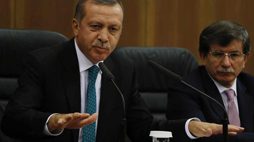 Turkish Prime Minister Tayyip Erdogan addresses the media next to Foreign Minister Ahmet Davutoglu (R) at Esenboga Airport in Ankara November 21, 2013. A feud between Erdogan and an influential Islamic cleric, Fethullah Gulen, has spilled into the open months ahead of elections, highlighting fractures in the religiously conservative support base underpinning his decade in power. REUTERS/Umit Bektas (TURKEY - Tags: POLITICS RELIGION) - RTX15NGG