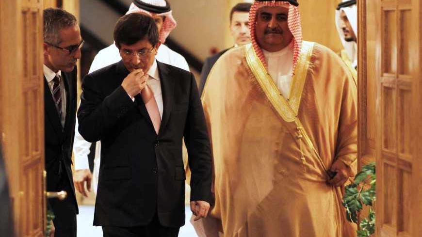 Turkish Foreign Minister Ahmet Davutoglu (C) listens to his advisor (L) as he walks in for a press briefing with Bahrain Foreign Minister Sheikh Khalid bin Ahmed al-Khalifa in Manama, November 24, 2013. REUTERS/Hamad I Mohammed (BAHRAIN - Tags: POLITICS) - RTX15R41