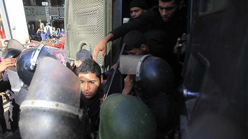 Riot police detain a man, who was protesting against a new law restricting demonstrations, in downtown Cairo November 26, 2013. Egyptian police fired a water cannon to disperse dozens of protesters near the Ministry of Interior on Tuesday after they defied the new law that restricts demonstrations. REUTERS/Amr Abdallah Dalsh (EGYPT - Tags: POLITICS CIVIL UNREST) - RTX15TTK