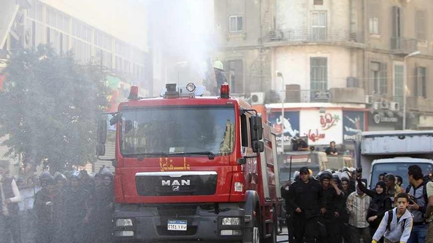 Riot police fire a water cannon to disperse people protesting against a new law restricting demonstrations, in downtown Cairo November 26, 2013. Egyptian police fired the water cannon to disperse dozens of protesters near the Ministry of Interior on Tuesday after they defied the new law. REUTERS/Amr Abdallah Dalsh (EGYPT - Tags: POLITICS CIVIL UNREST) - RTX15TTL