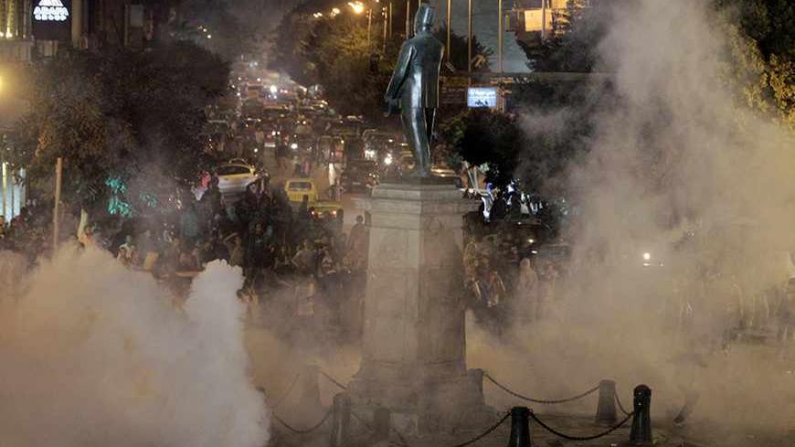 Tear gas fired by riot police at protesters fill the air during clashes at Talaat Harab square in downtown Cairo November 26, 2013. Protesters took to the streets on Tuesday in defiance of a law passed on Sunday requiring police approval for gatherings of more than 10 people. REUTERS/Mohamed Abd El Ghany (EGYPT - Tags: POLITICS CIVIL UNREST) - RTX15U75