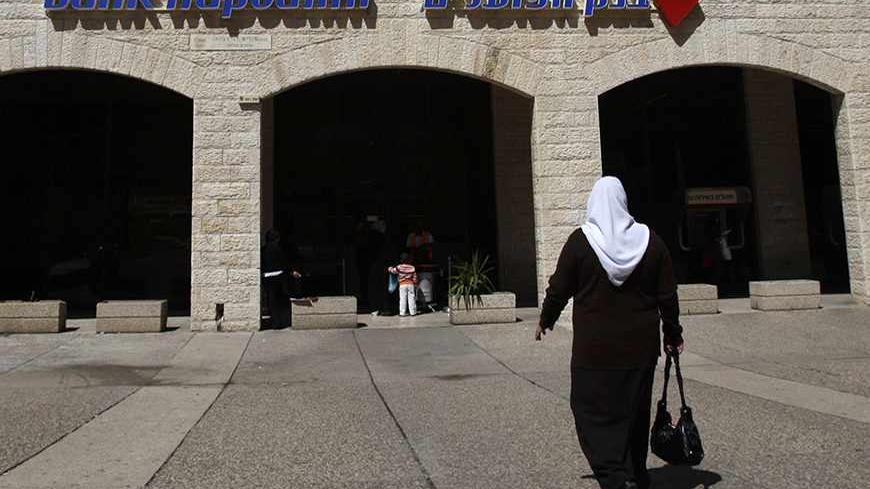 A pedestrian walks outside a branch of Bank Hapoalim in Jerusalem March 26, 2009. Bank Hapoalim, Israel's largest lender in terms of assets, should return to profitability in the first quarter after posting a loss in the 
fourth quarter, its chairman said on Thursday. 
REUTERS/Baz Ratner (JERUSALEM BUSINESS) - RTXD7YQ