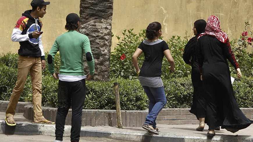 Youth try to harass women on a street in Cairo April 8, 2013. Egypt's National Council for Women (NCW) has proposed a new law against sexual harassment containing a minimum sentence of one-year imprisonment for first-time offenders, local media reported.  Picture taken April 8, 2013. REUTERS/Amr Abdallah Dalsh (EGYPT - Tags: POLITICS) - RTXYEPA