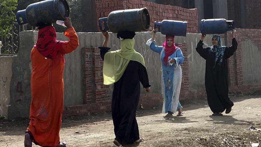 Women carry gas cylinders to be refilled on the outskirts of Cairo, April 1, 2013. REUTERS/Asmaa Waguih (EGYPT - Tags: SOCIETY TPX IMAGES OF THE DAY) - RTXY4WW