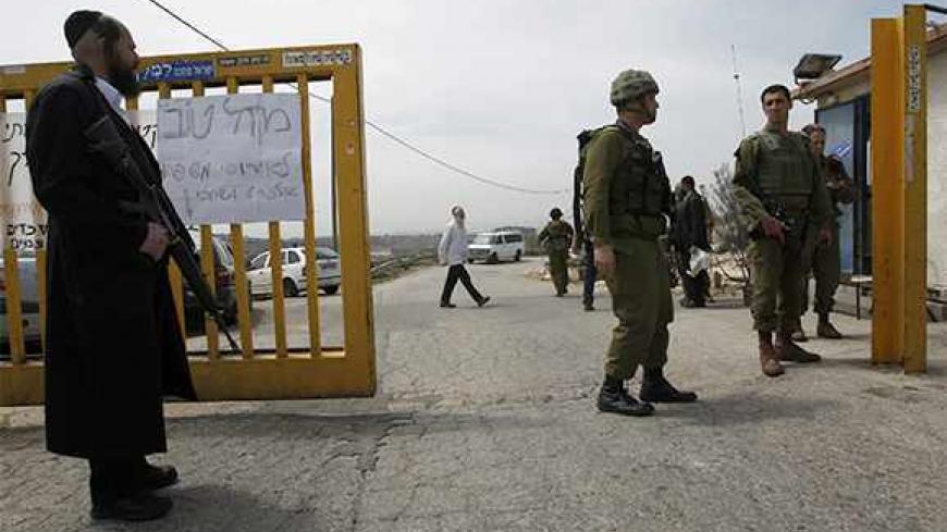 Israeli soldiers (R) and a Jewish settler (L) stand at the entrance to the West Bank Jewish settlement of Bat Ayin, near Hebron April 2, 2009, after an attack. A Palestinian with an axe and a knife killed a 13-year-old Israeli boy and wounded a seven-year-old boy in Bat Ayin on Thursday, two days after a right-wing government took power.
REUTERS/Ronen Zvulun (WEST BANK POLITICS CONFLICT IMAGE OF THE DAY TOP PICTURE) - RTXDJ9O