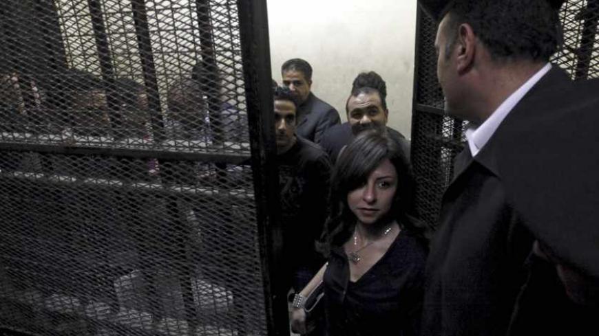 Activists, accused of working for unlicensed non-governmental organizations (NGOs) and receiving illegal foreign funds, stand in a cage during the opening of their trial in Cairo March 8, 2012. An Egyptian judge said on Thursday he was delaying until April 10 the trial of civil society activists including 16 Americans accused of receiving illegal foreign funds and pursuing their pro-democracy activities without a licence. REUTERS/Mohamed Abd El Ghany  (EGYPT - Tags: CIVIL UNREST POLITICS CRIME LAW) - RTR2Z1