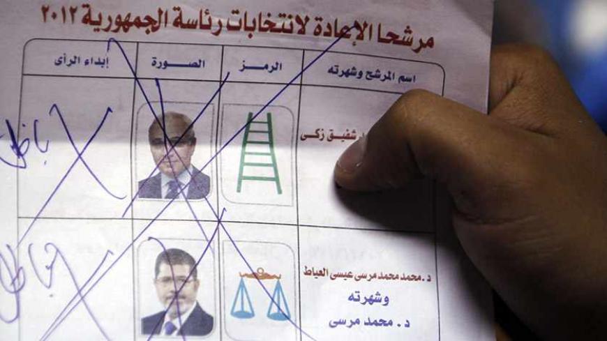 An electoral worker shows an invalid ballot, on which a voter has marked with multiple crosses and written "void" next to both candidates, after polls closed in Cairo June 17, 2012. Egyptians began an anxious wait for their first freely elected president on Sunday after two days of voting that was to be the culmination of their Arab Spring revolution but which many fear may now only compound political and economic uncertainty. REUTERS/Amr Abdallah Dalsh  (EGYPT - Tags: POLITICS ELECTIONS) - RTR33SJ4